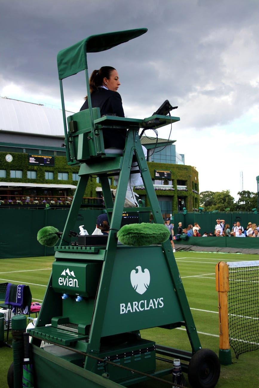 A tennis umpire chair with barclays and evian brands on them
