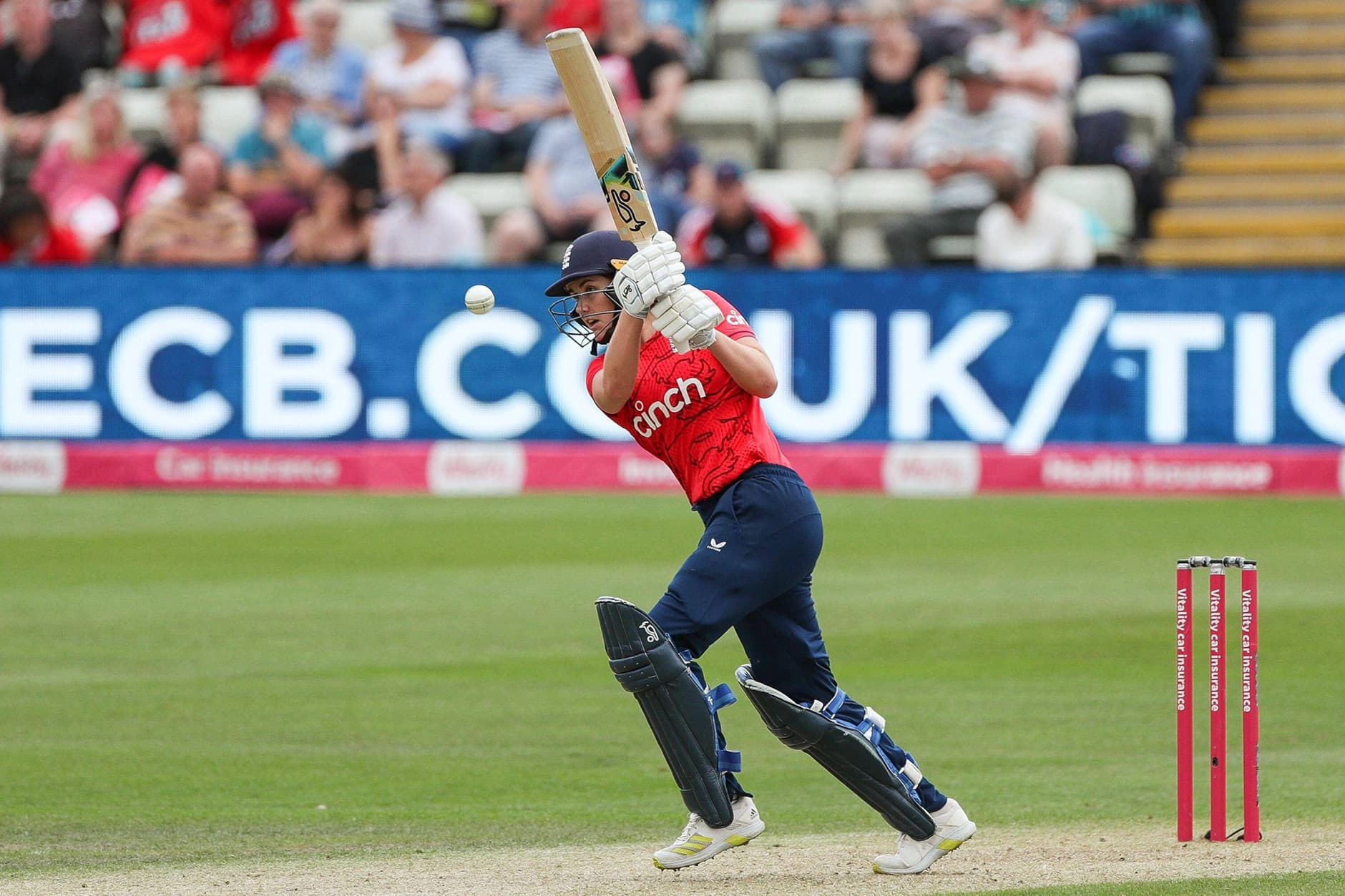 A cricket player hitting a cricket ball