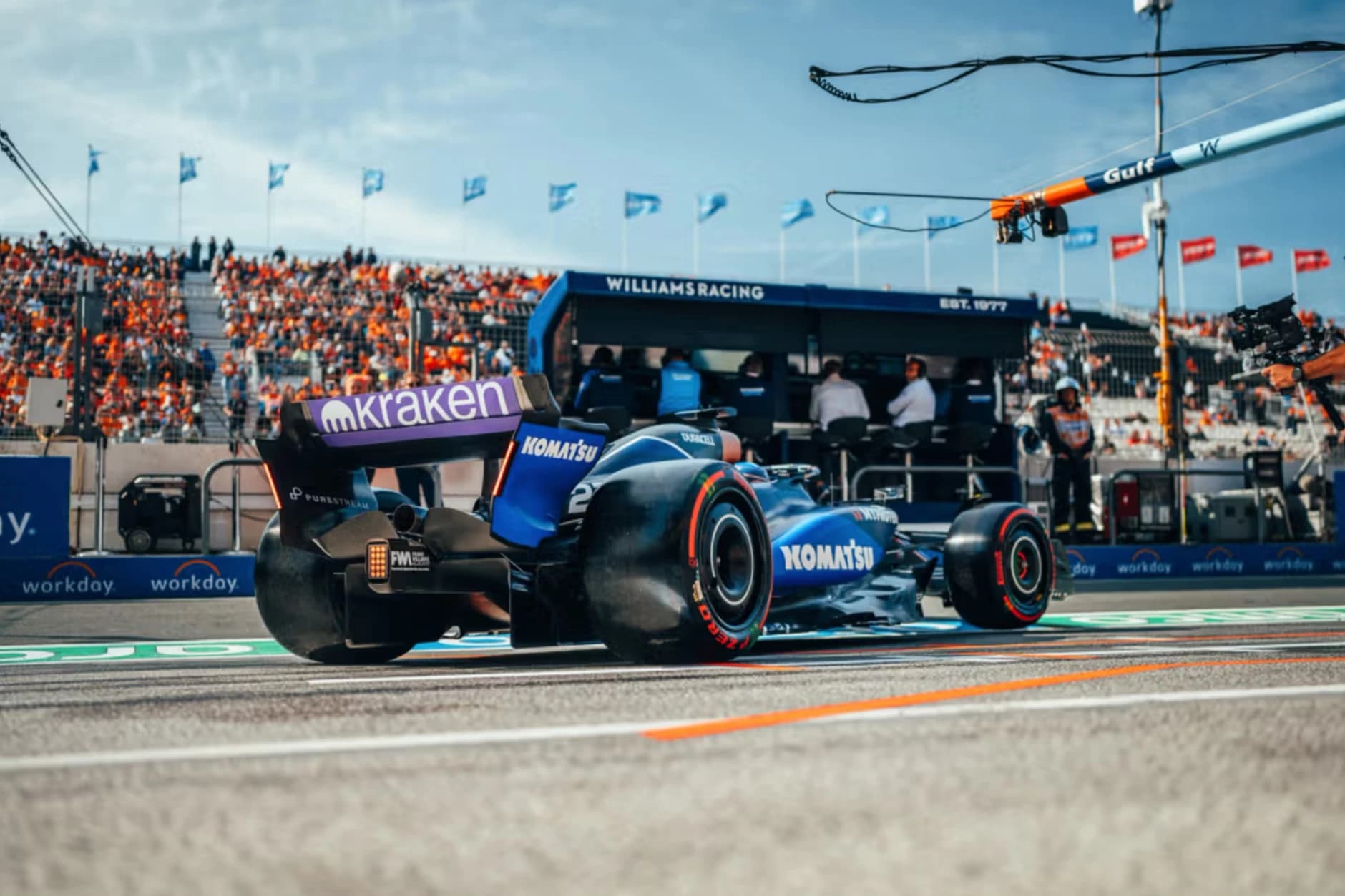 A motorsport car in motion showcasing multiple brnad adverts on it